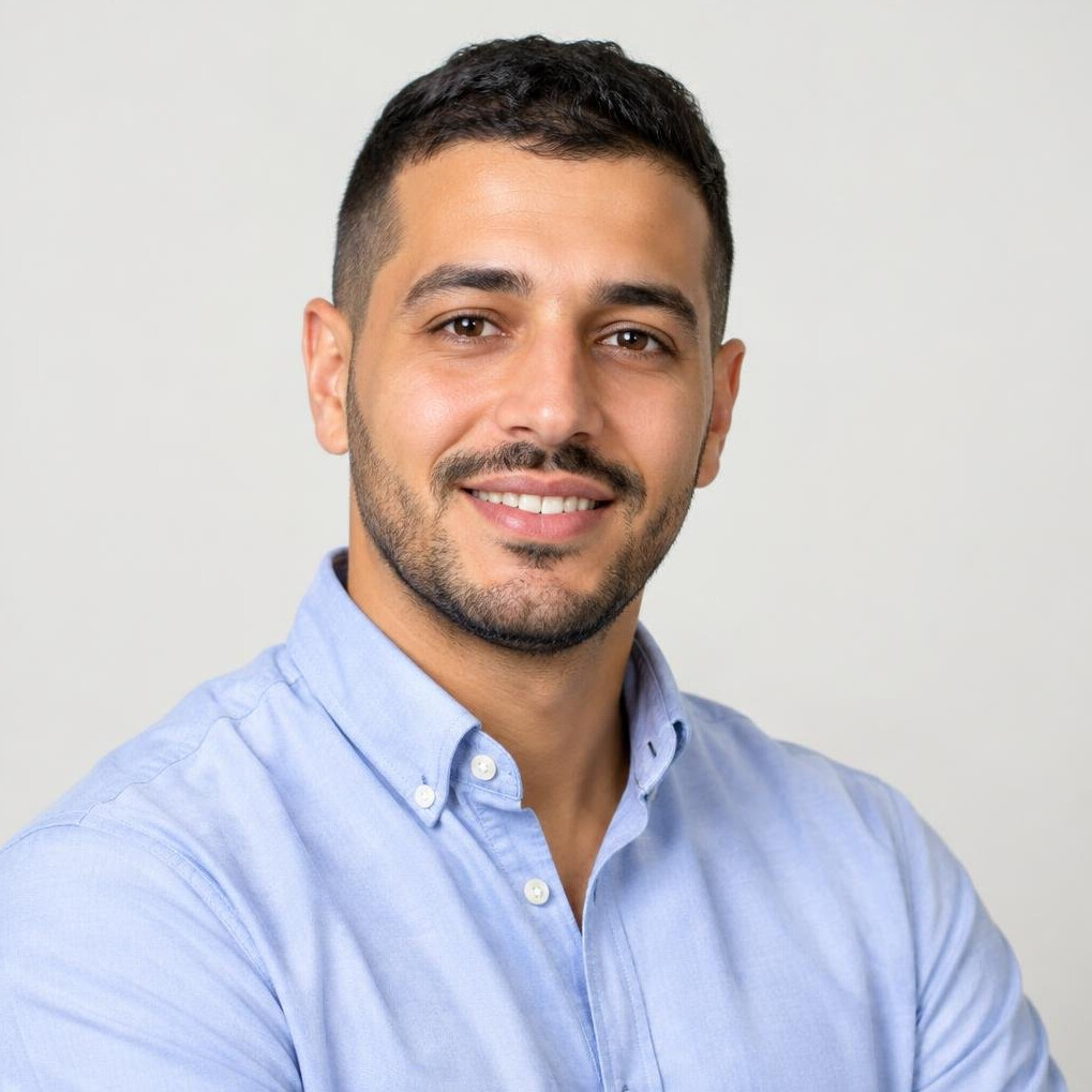 Portrait of a man of North African descent in his 30s smiling